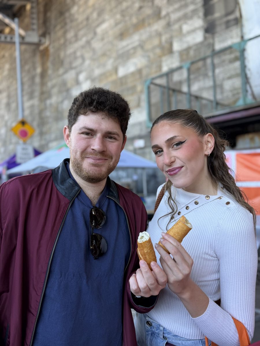 Two friends holding desserts under the viaduct