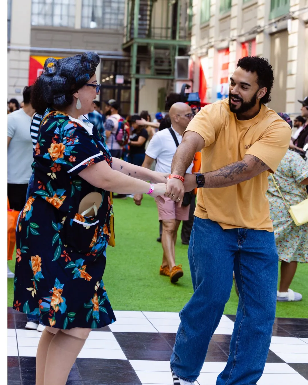 Two festivalgoers dancing on the checkerboard floor